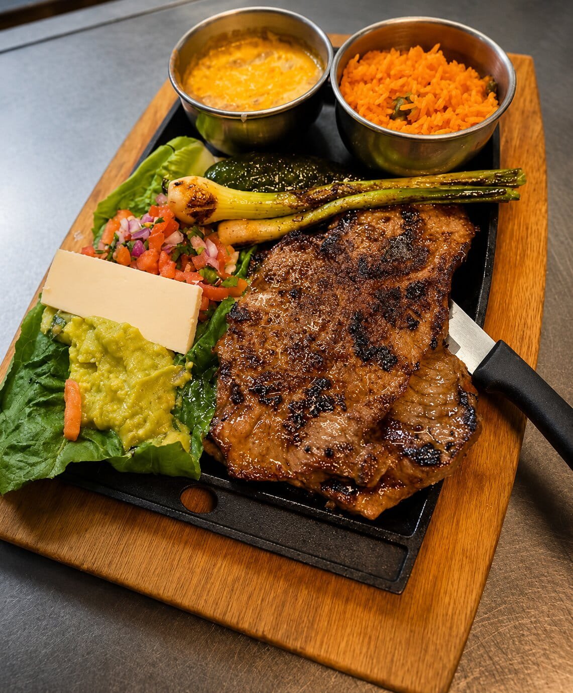 Grilled steak served with colorful sides and cheese at Ay Caramba