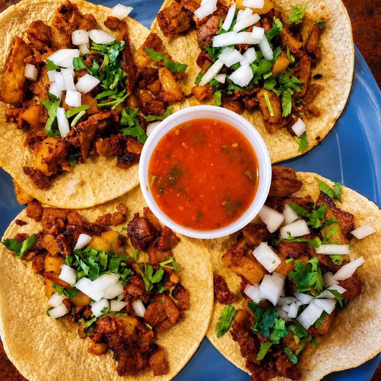Tacos al pastor served with salsa at Ay Caramba